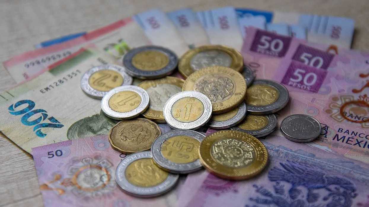 Mexican peso coins scattered across assorted banknotes.