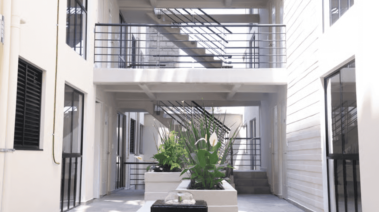 Modern apartment courtyard with planters and external staircases.