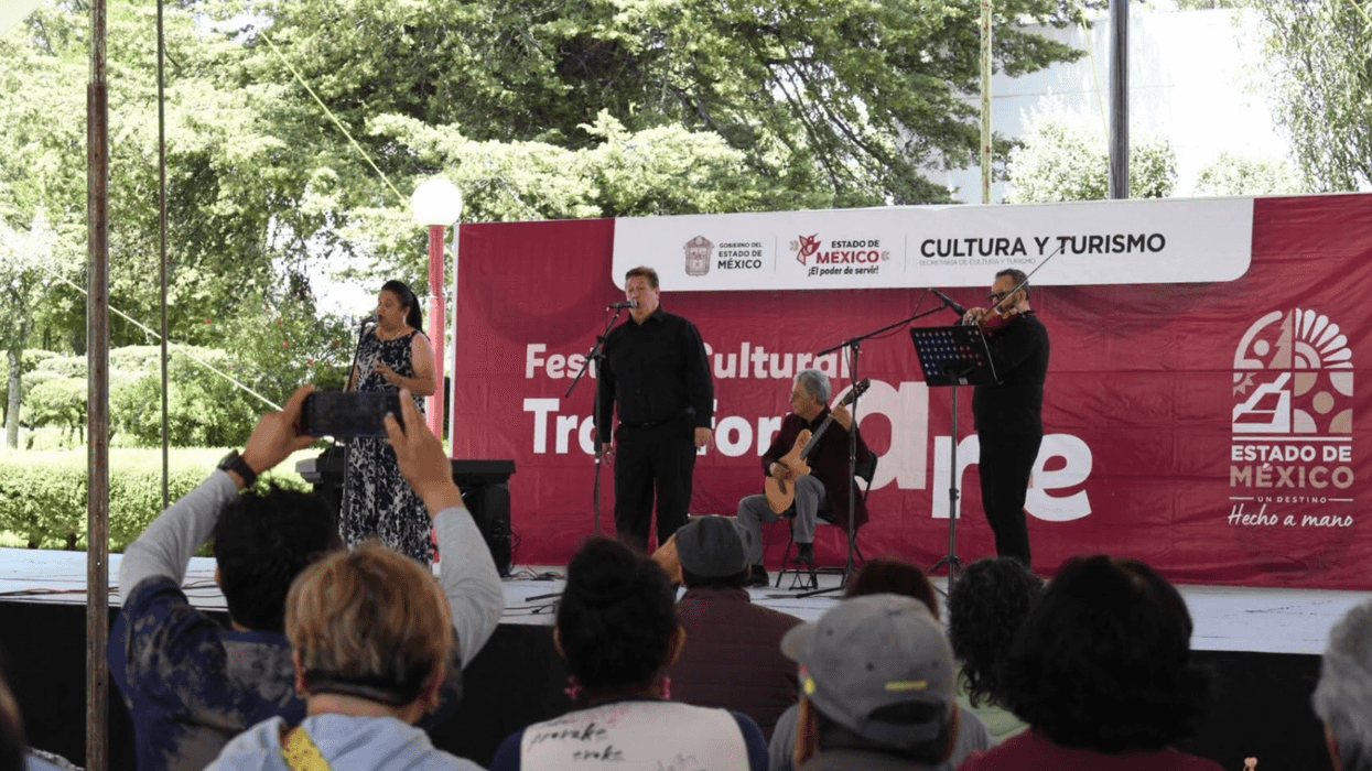 Musicians perform on stage at a cultural festival in Mexico with a banner behind them.
