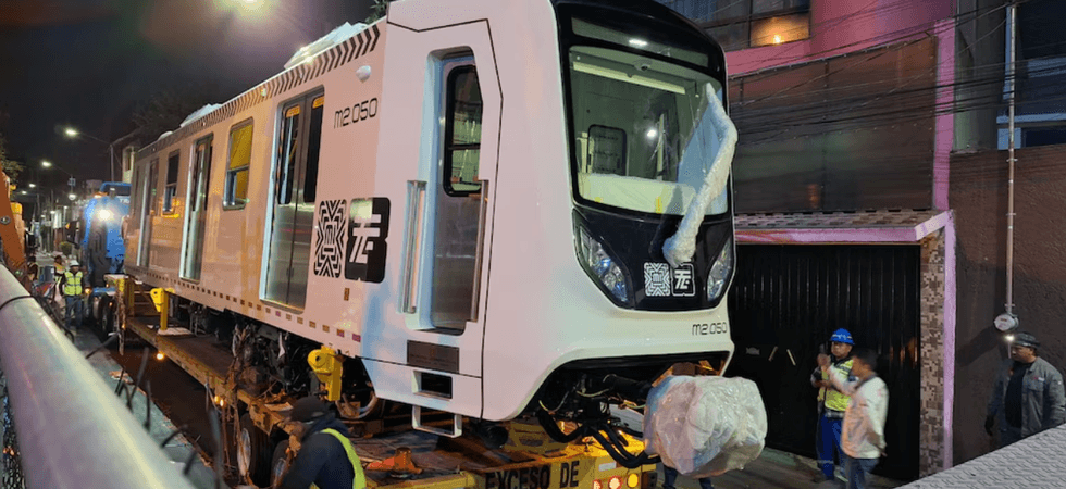 New subway train carriage being transported on a truck at night.