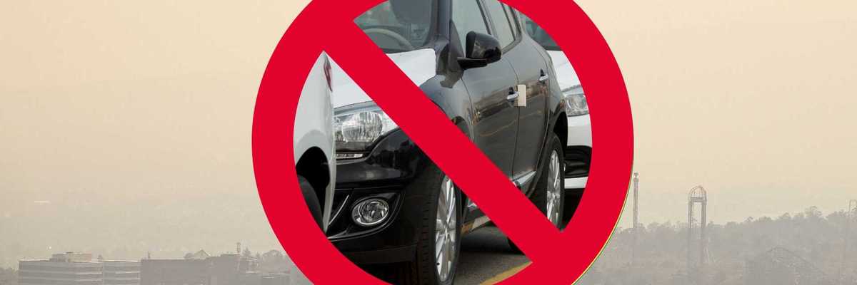 No cars symbol over cityscape with smog.