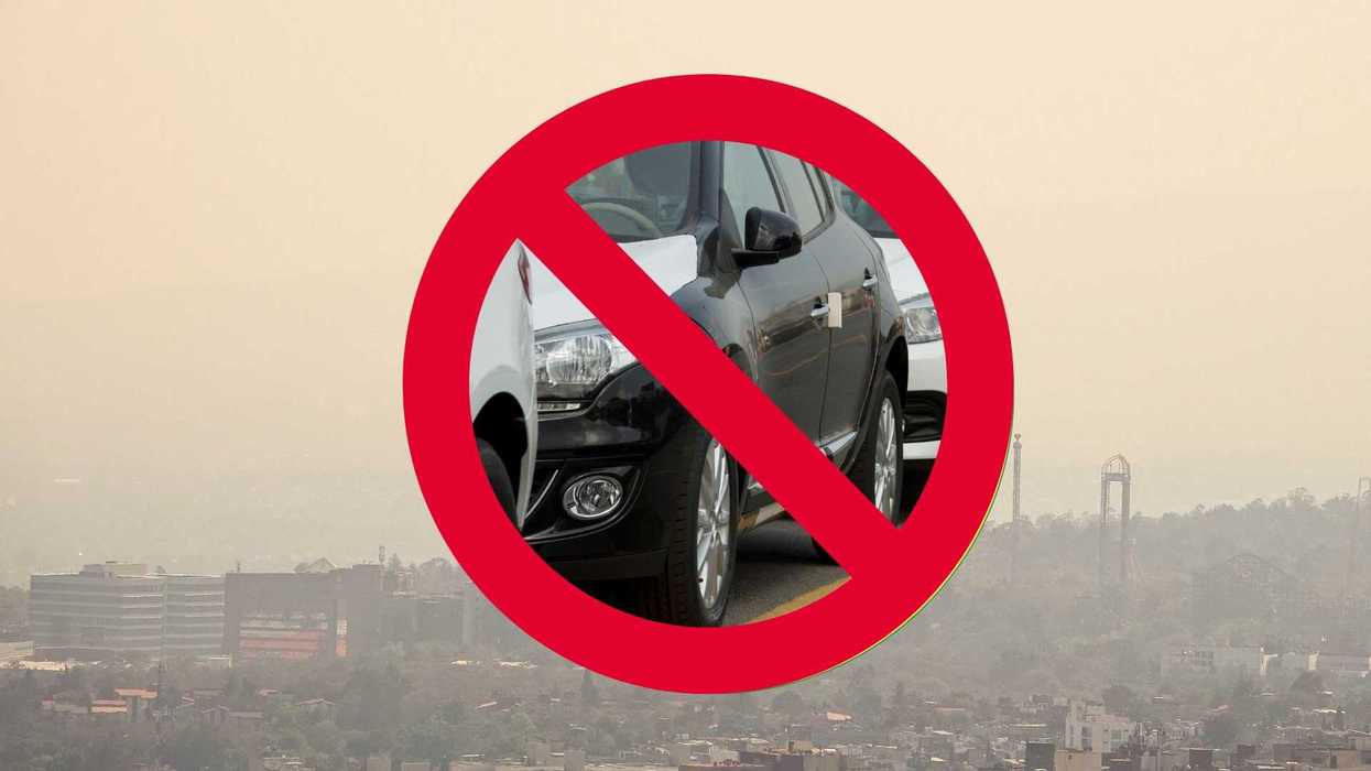 No cars symbol over cityscape with smog.