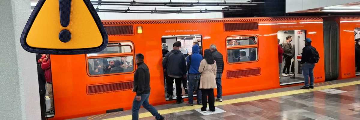 Orange metro train at station, people boarding, triangular warning sign in foreground.