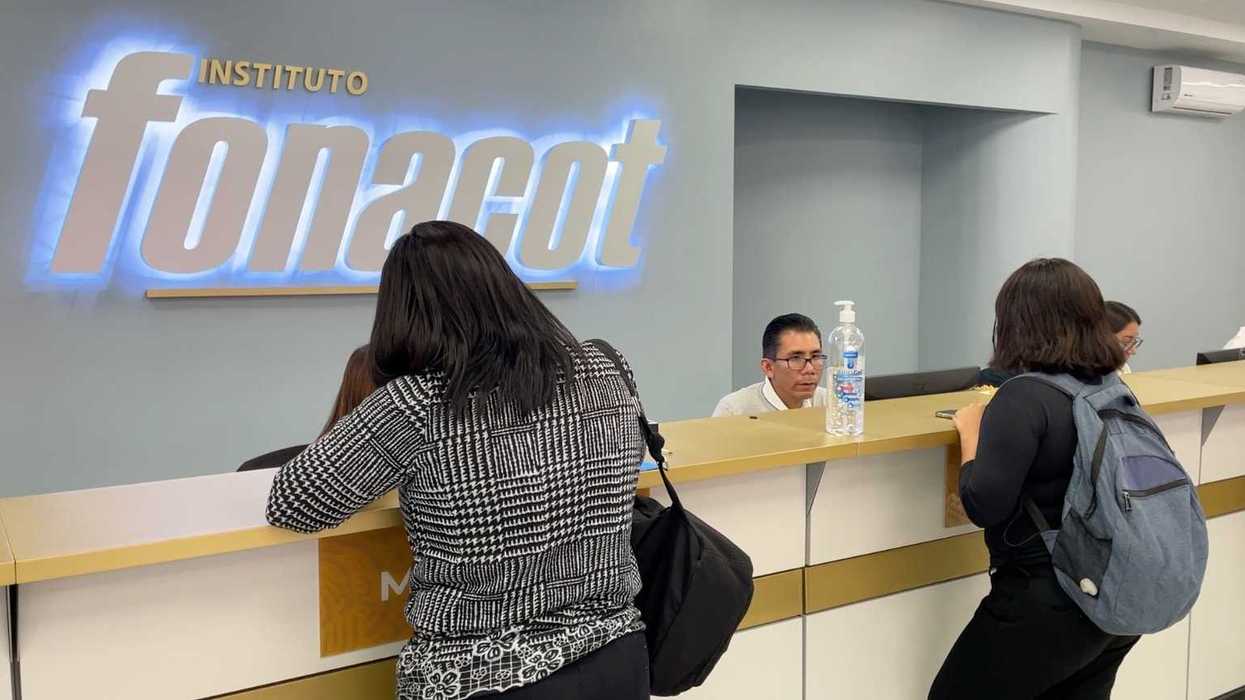 People at a reception desk of Instituto Fonacot, talking to an employee.