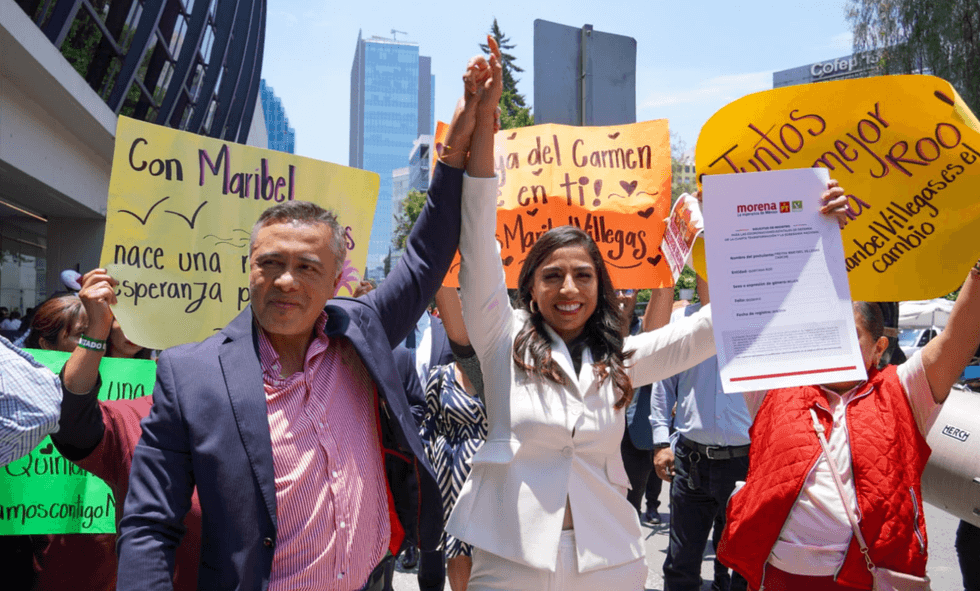 People holding signs and linked arms, celebrating outdoors in a city street.