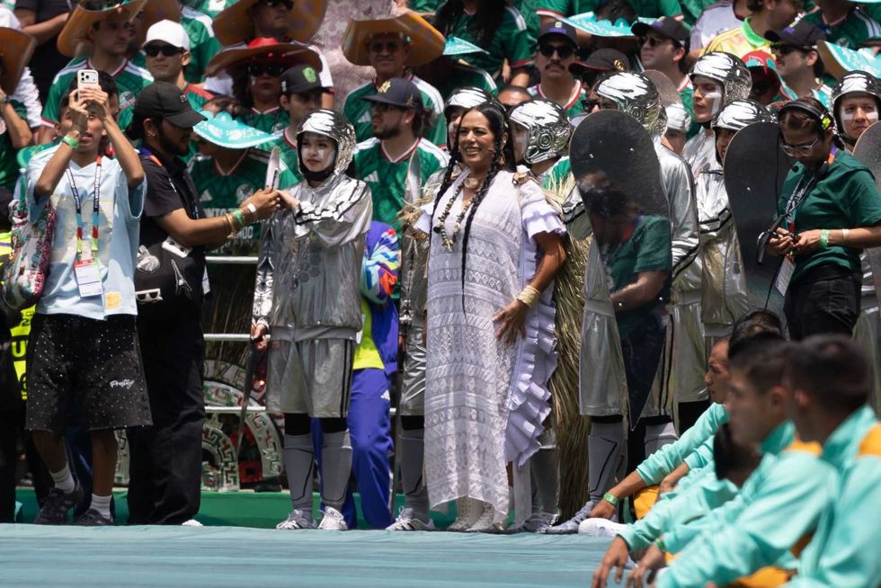 People in colorful costumes and silver outfits at a lively outdoor event.