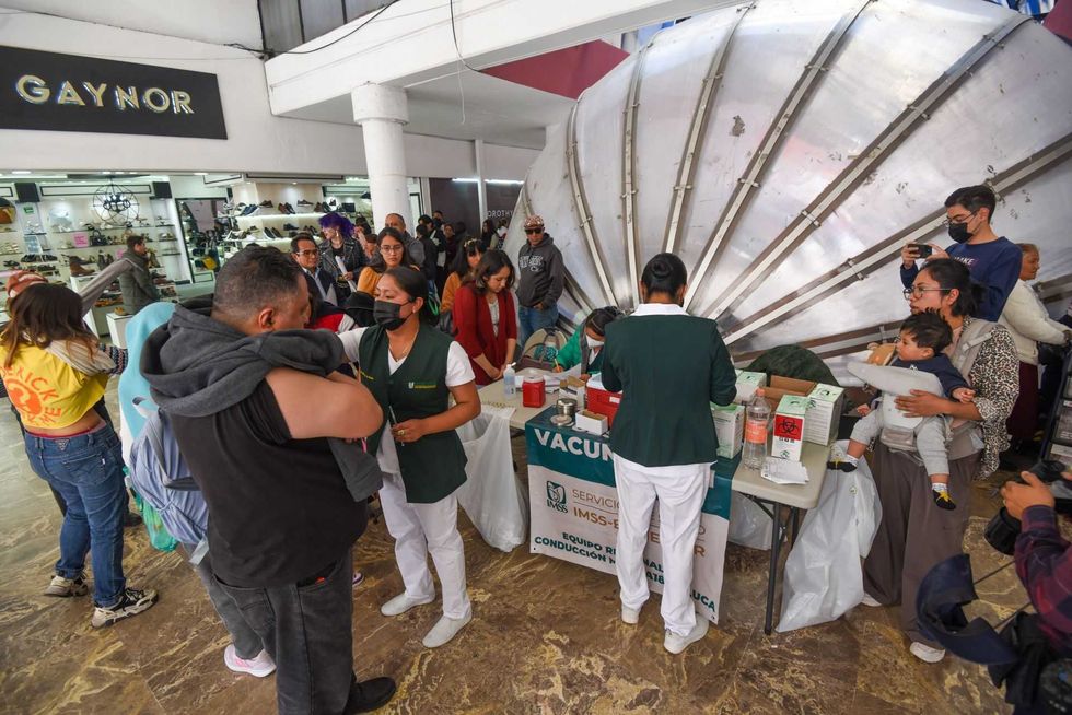 People in line at a vaccination clinic in a public space with healthcare workers.