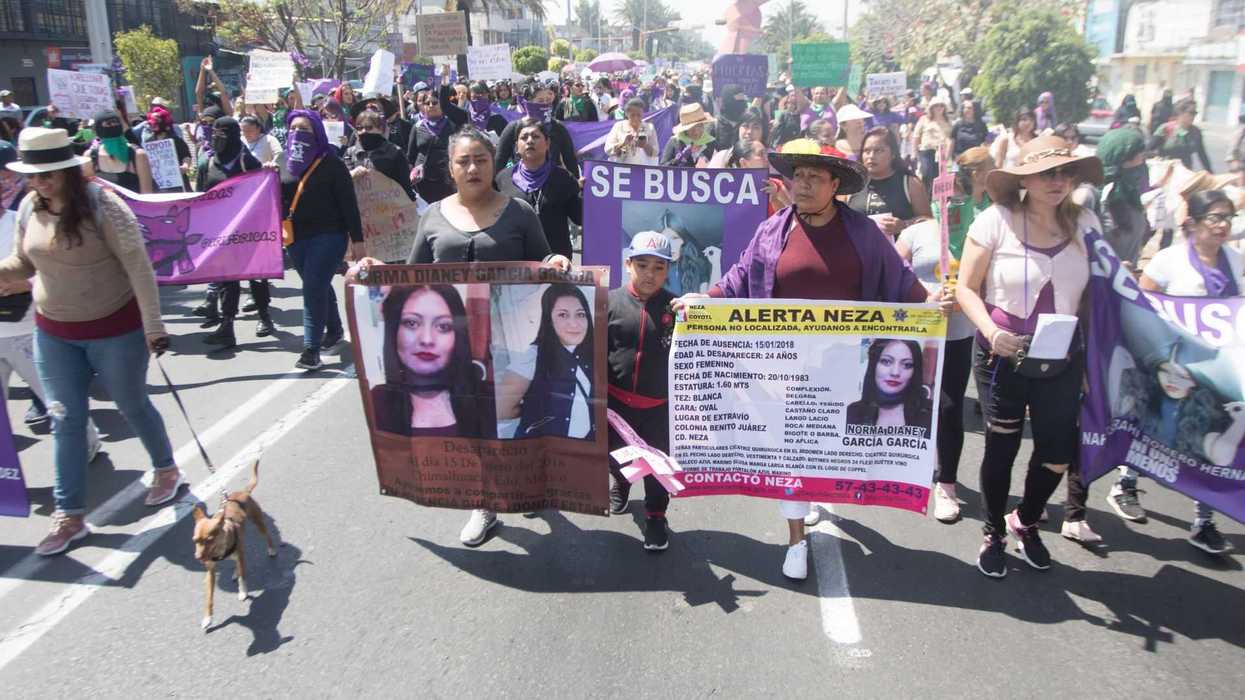 People marching with banners for missing persons, holding posters and placards in a protest.