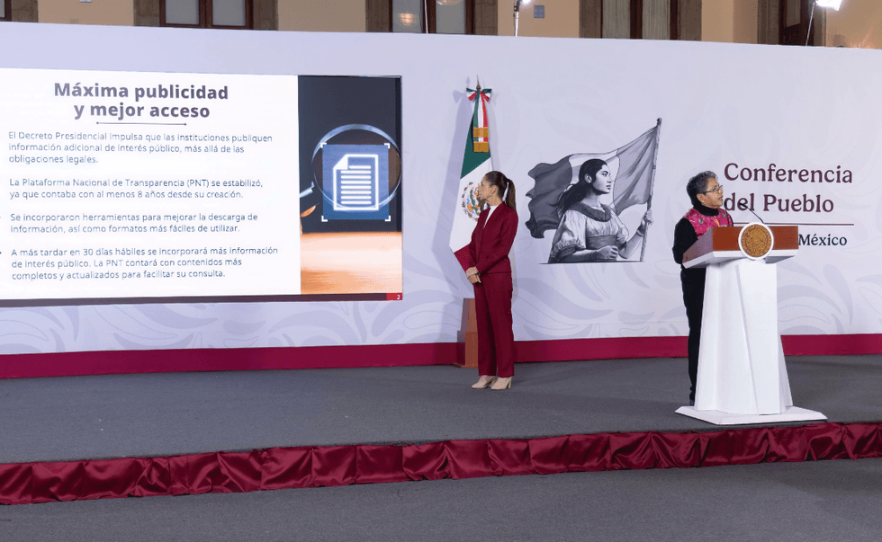 People present at a conference podium with a presentation on transparency in Mexico.