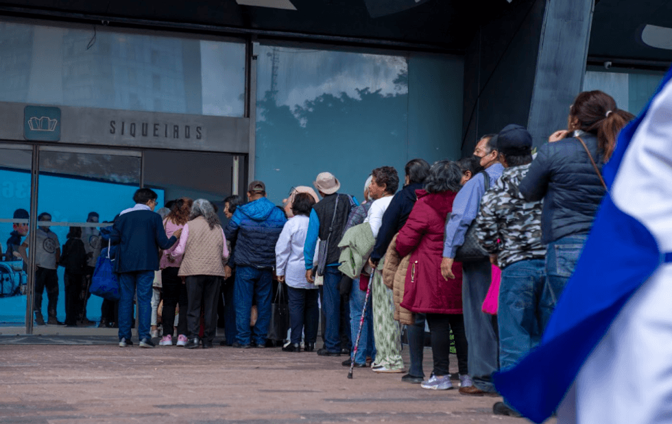 People waiting in line outside a building labeled "SIQUEIROS."