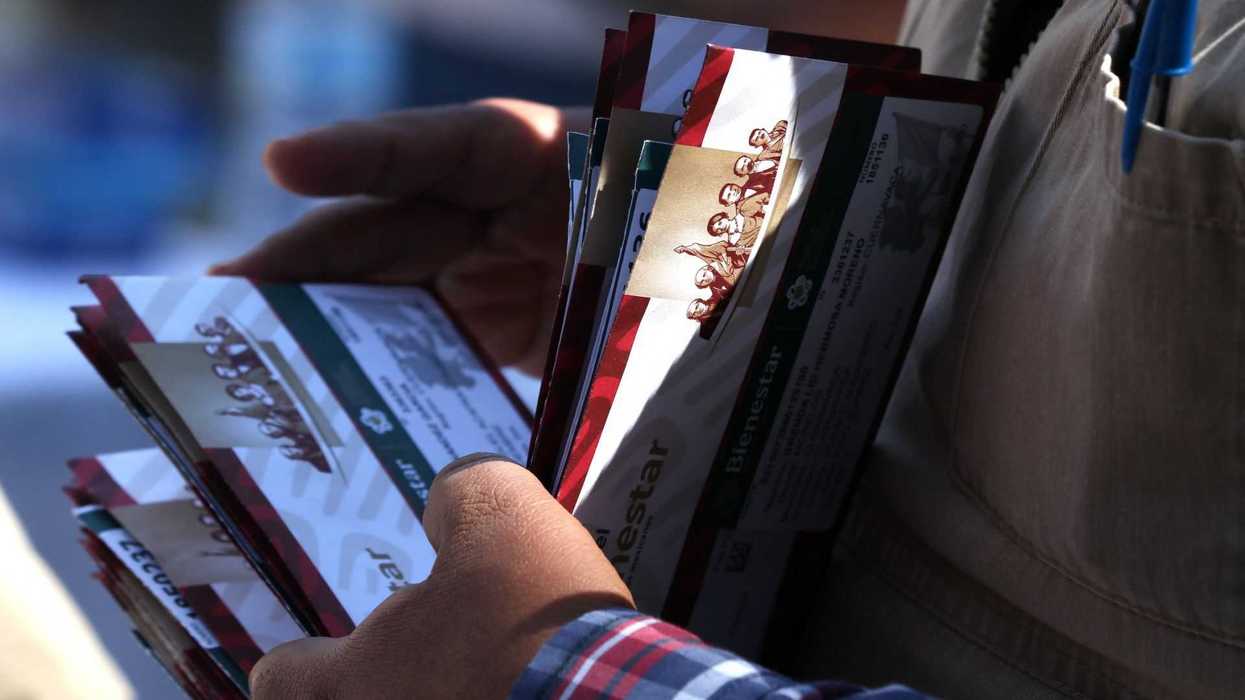 Person holding a fan of Mexican government pamphlets.