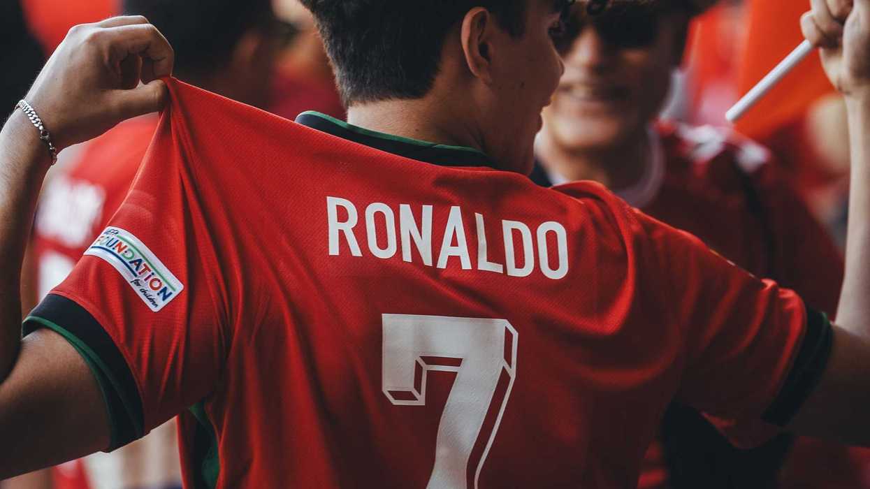 Person in a red jersey with "Ronaldo 7" on the back, surrounded by fans.