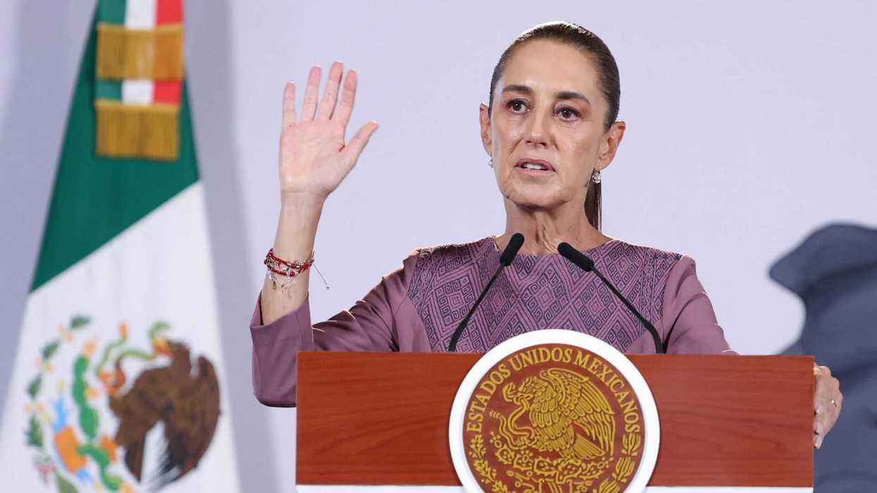 Person speaking at a podium, Mexican flag in the background.