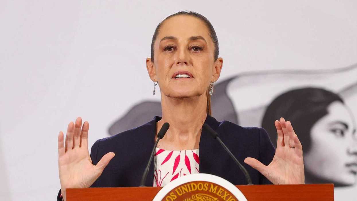 Person speaking at a podium with a microphone, gesturing with hands.