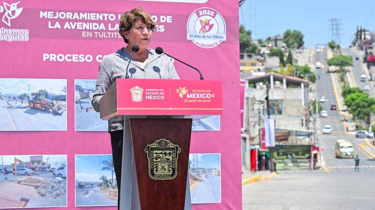 Person speaking at a podium with urban development images behind them.