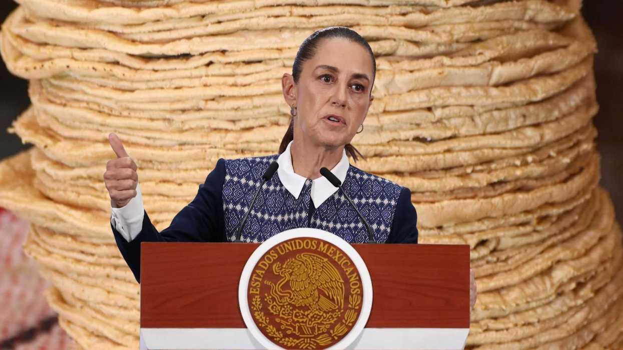 Person speaking at podium with large stack of tortillas in the background.