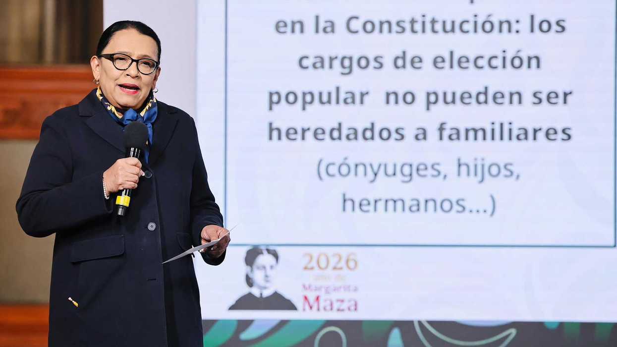 Person speaking near a screen displaying a message about political positions and family inheritance.