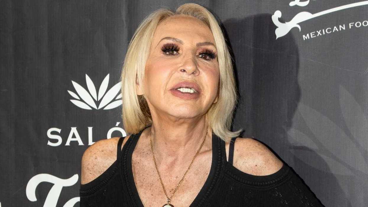 Person with blonde hair at an event, wearing a black off-shoulder top.
