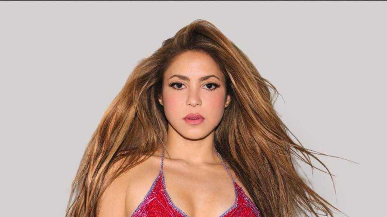 Person with long hair wearing a red top against a plain background.