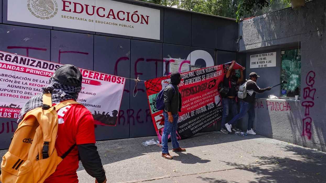 Protesters hang banners at the National Ministry of Education building.