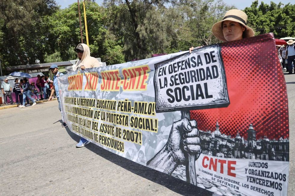 Protesters holding a banner defending social security and opposing education reforms.