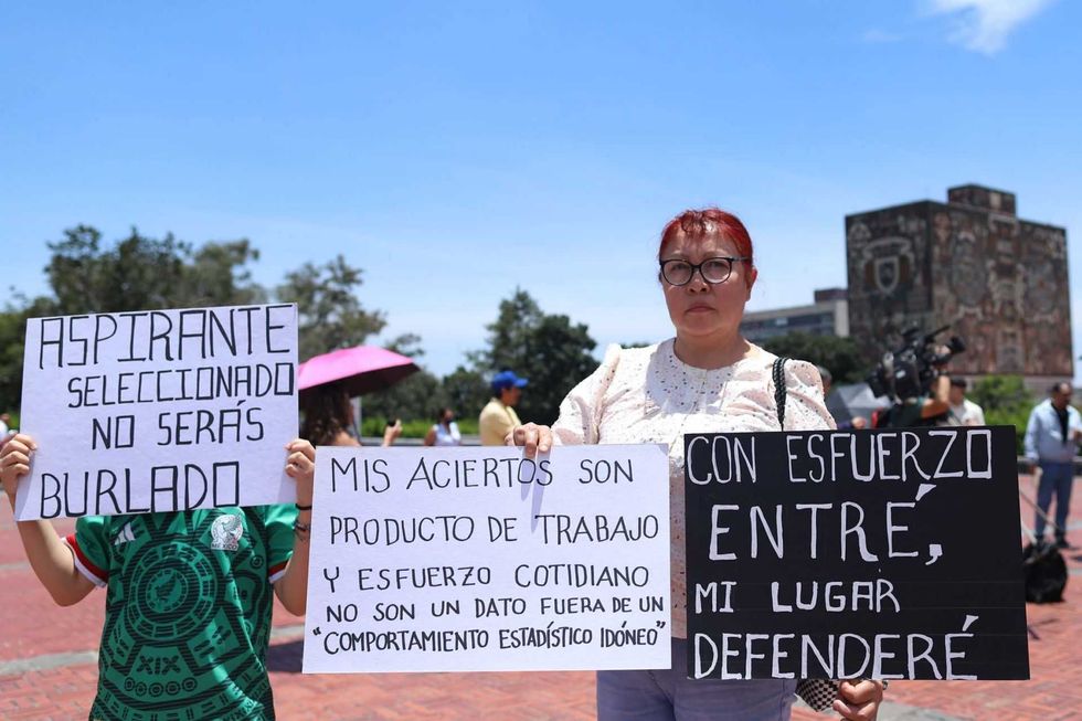 Protesters holding signs in Spanish about effort and rightful selection.