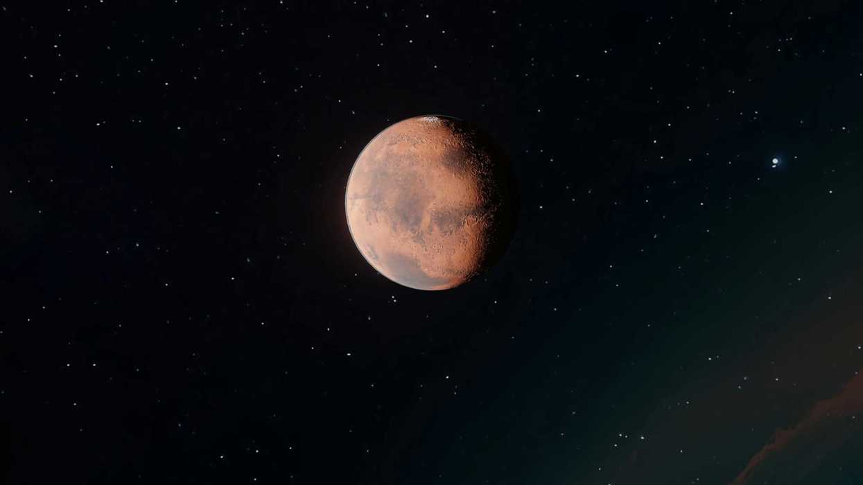 Red planet Mars against a starry black sky.