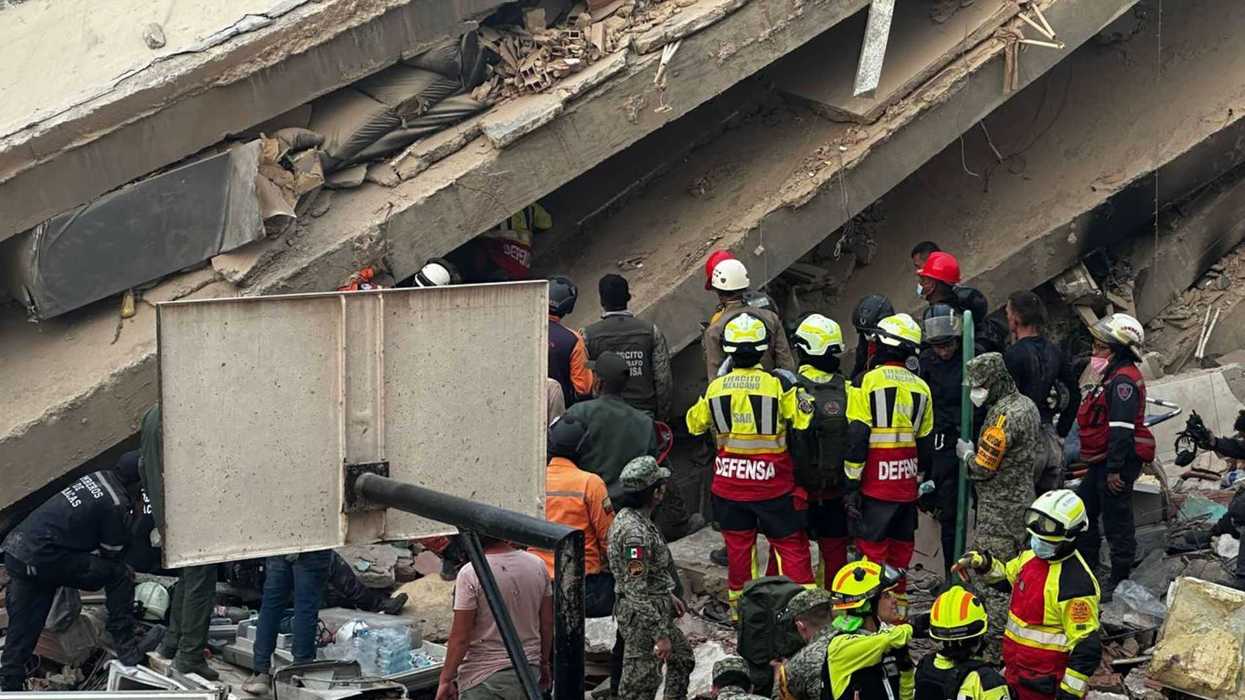 Rescue workers search through building rubble after a collapse.