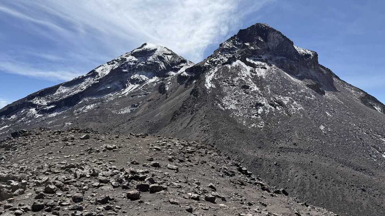 Rocky, snow-dusted mountain peaks under a clear blue sky.