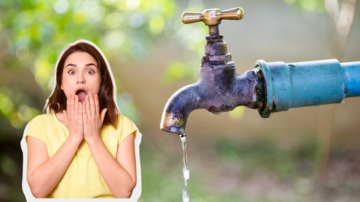 Shocked woman next to a leaking outdoor water faucet.