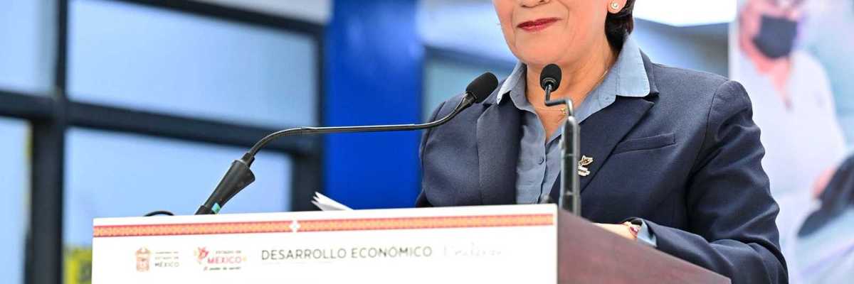 Smiling person at podium during an investment announcement event.
