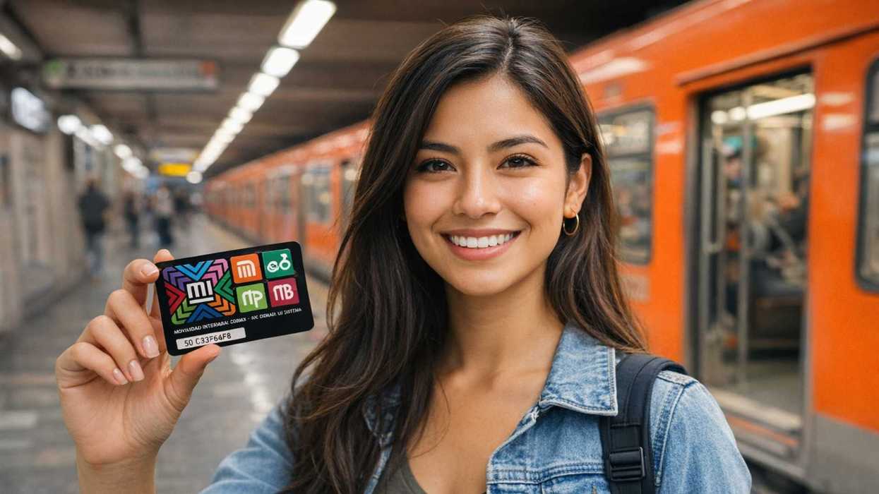 Smiling woman holding a transport card in a subway station with an orange train.