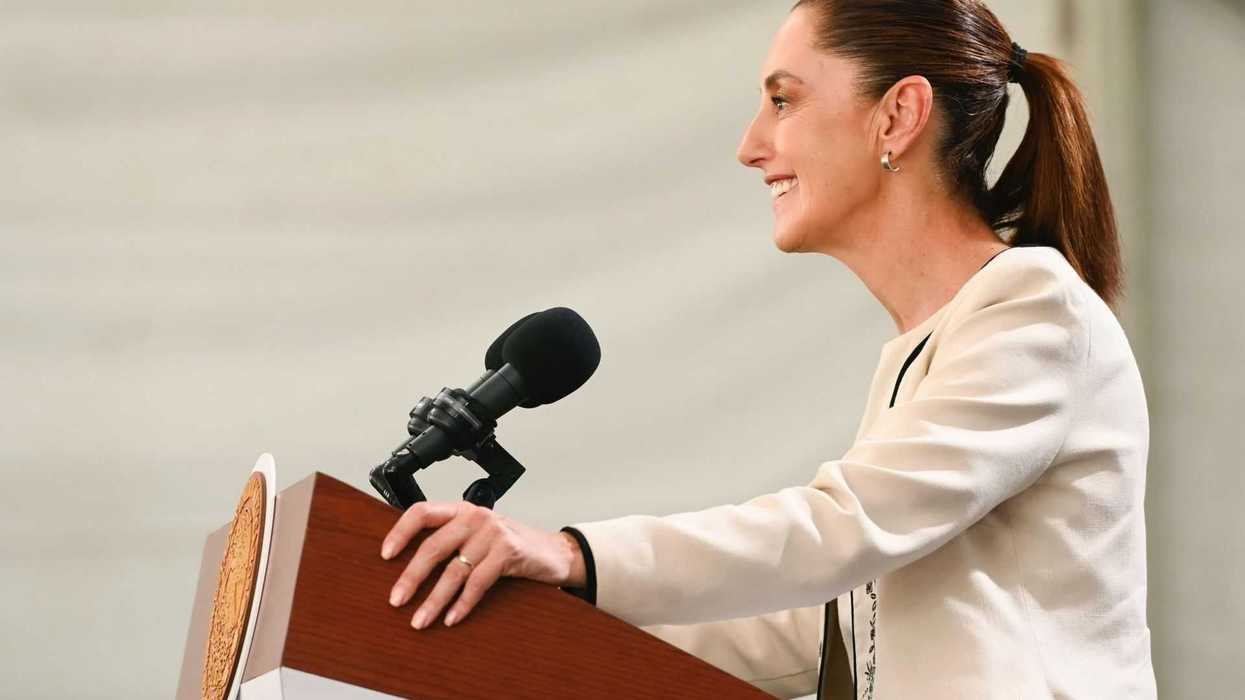 Smiling woman speaking at a podium with a microphone.