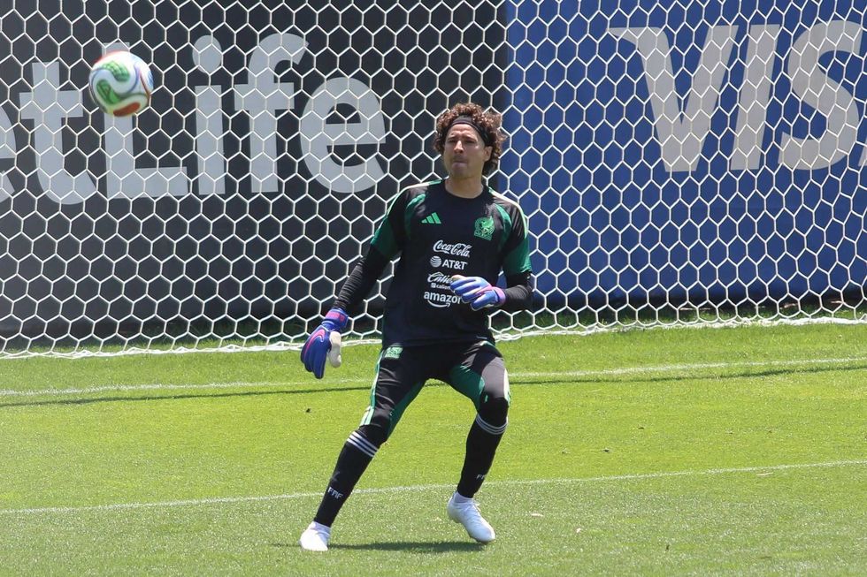 Soccer goalie in action, focused and ready to save a ball on the field.