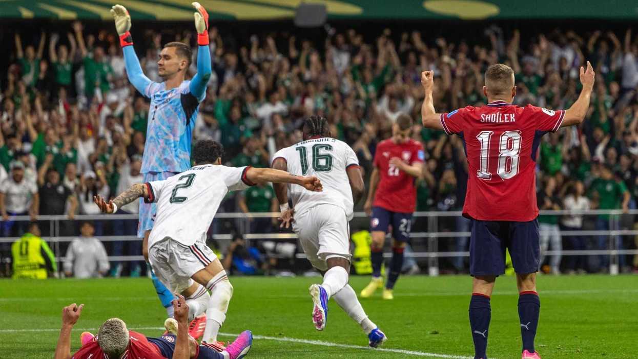 Soccer match reaction: players in action, with cheering crowd in the background.