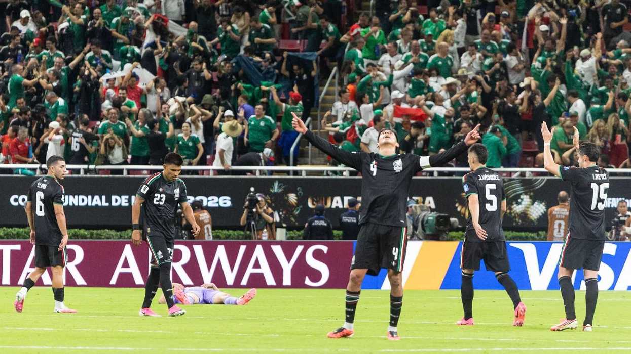 Soccer players celebrate on field, fans cheer in stadium stands above.
