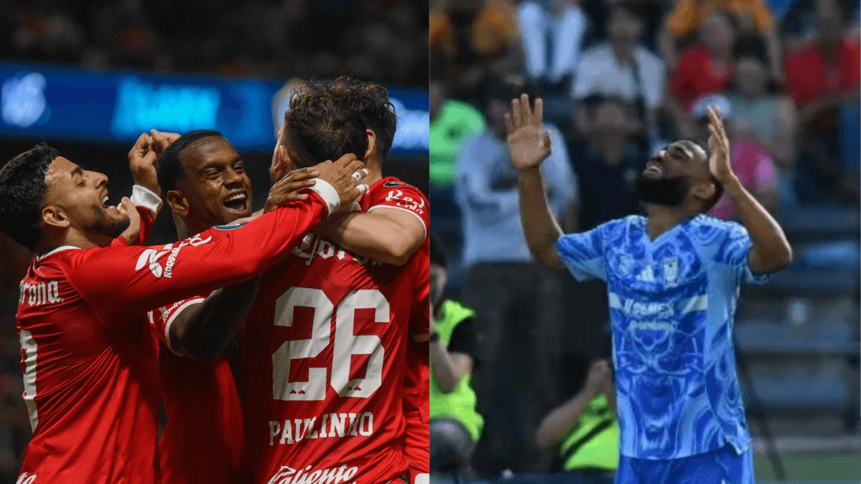 Soccer players in red celebrate; player in blue raises hands, looking up.