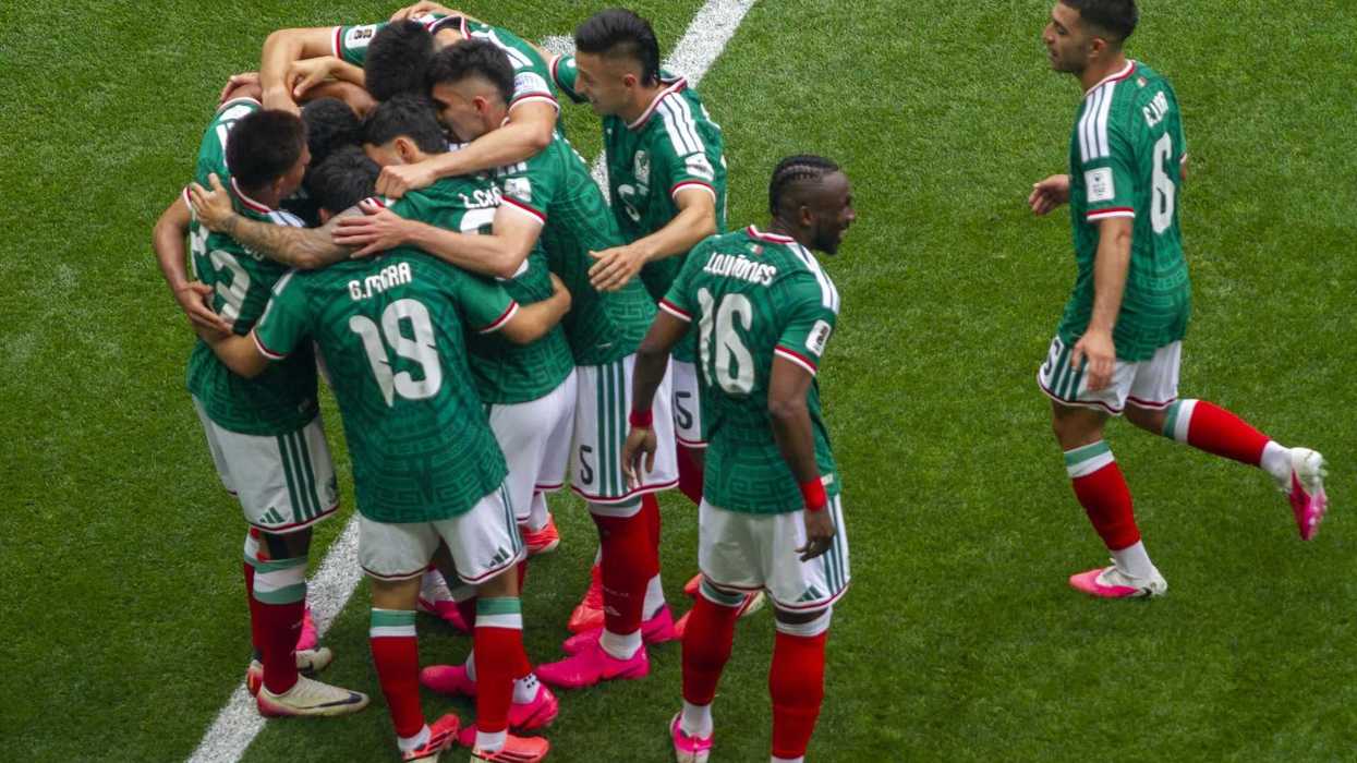 Soccer team in green jerseys celebrating a goal on the field.