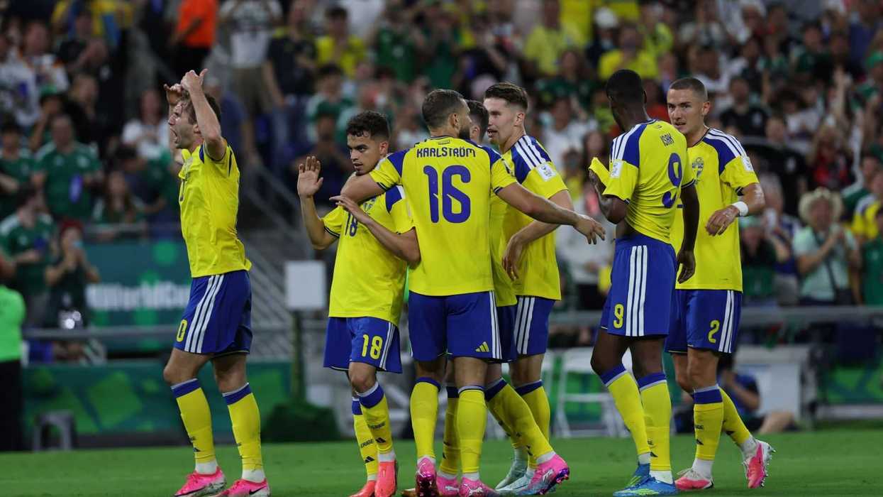 Soccer team in yellow jerseys celebrating a goal on the field.