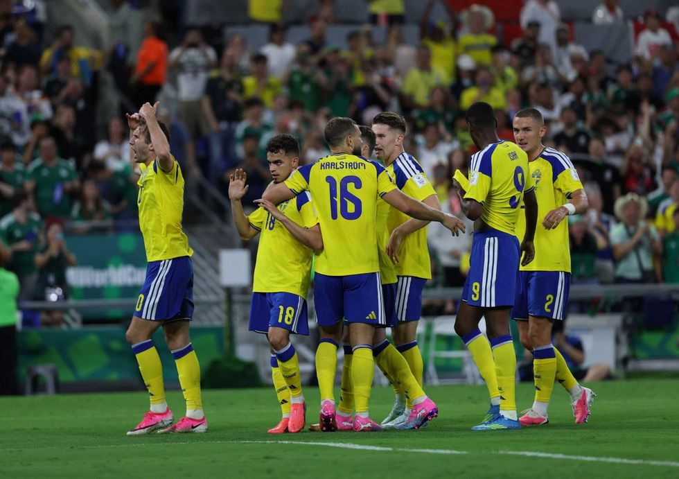 Soccer team in yellow jerseys celebrating a goal on the field.