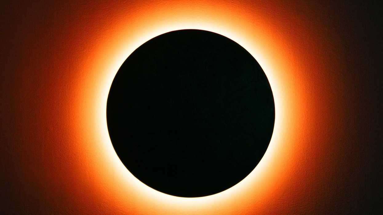 Solar eclipse with glowing orange ring against a black circle.
