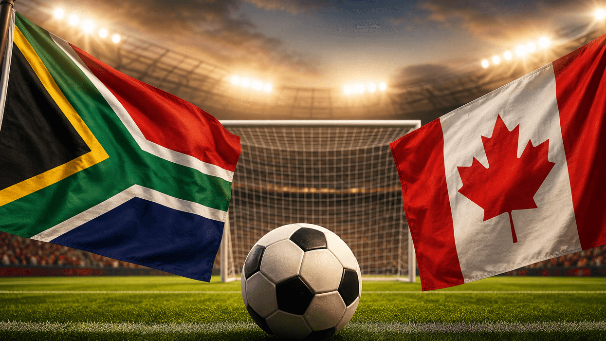 South African and Canadian flags with soccer ball on a stadium field.