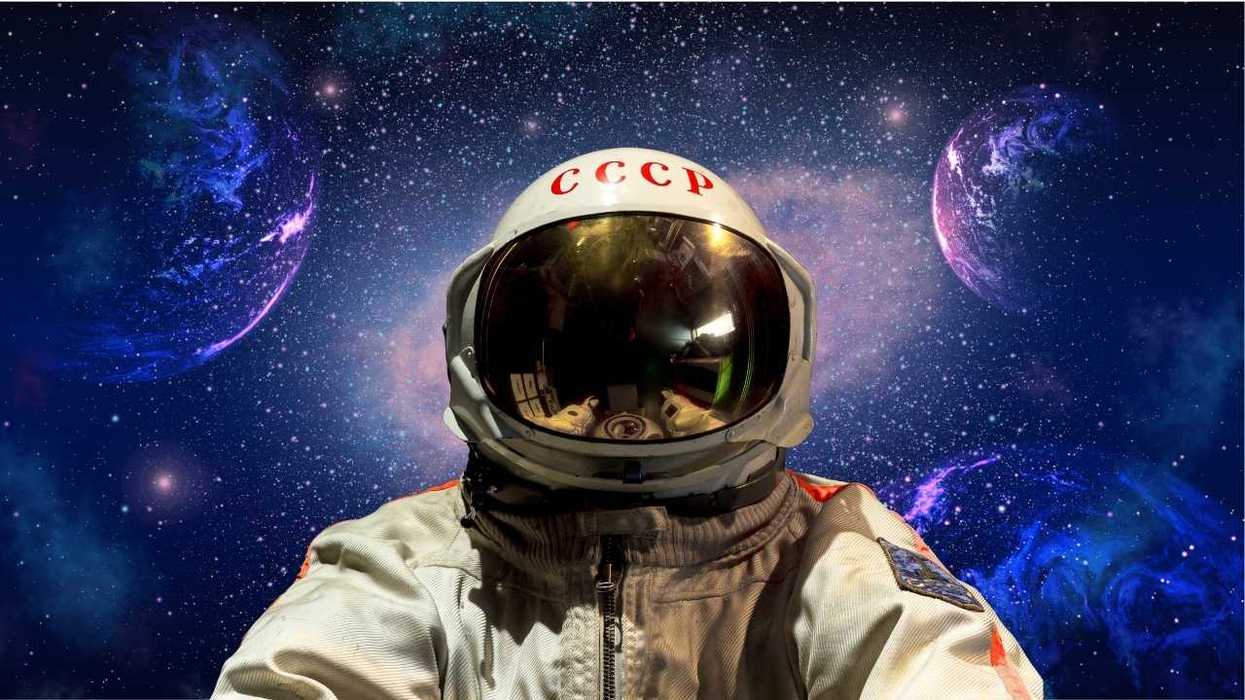 Soviet astronaut in space suit with cosmic background of stars and planets.
