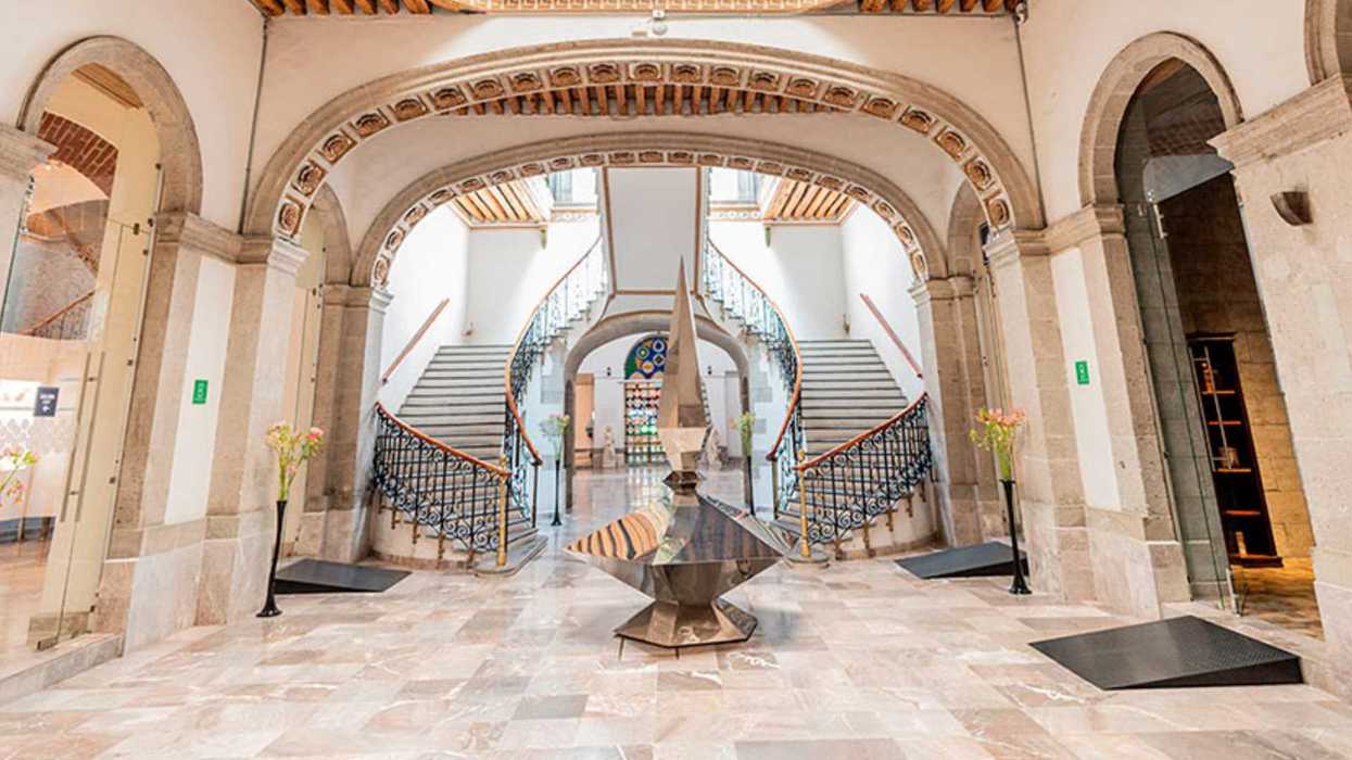 Spacious hall with twin spiral staircases and decorative columns.