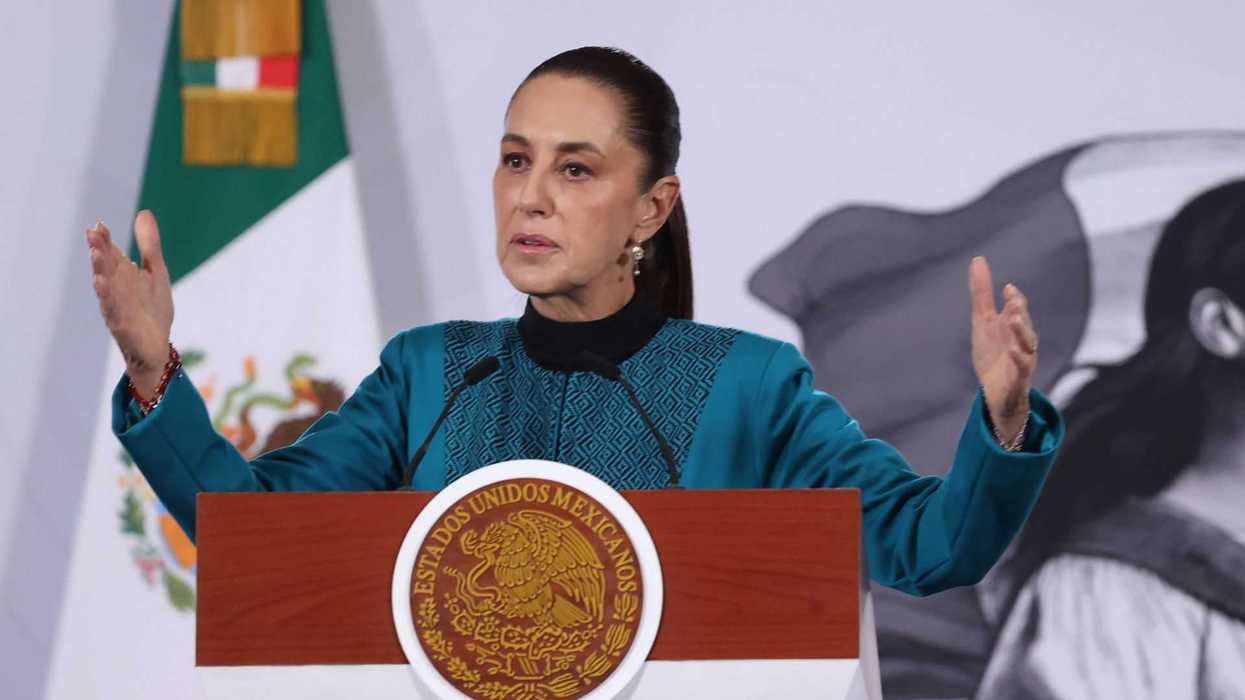 Speaker in blue addresses an audience at a podium with Mexican emblem.