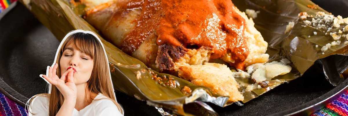 Tamale with sauce on banana leaf, woman gesturing delight in foreground.