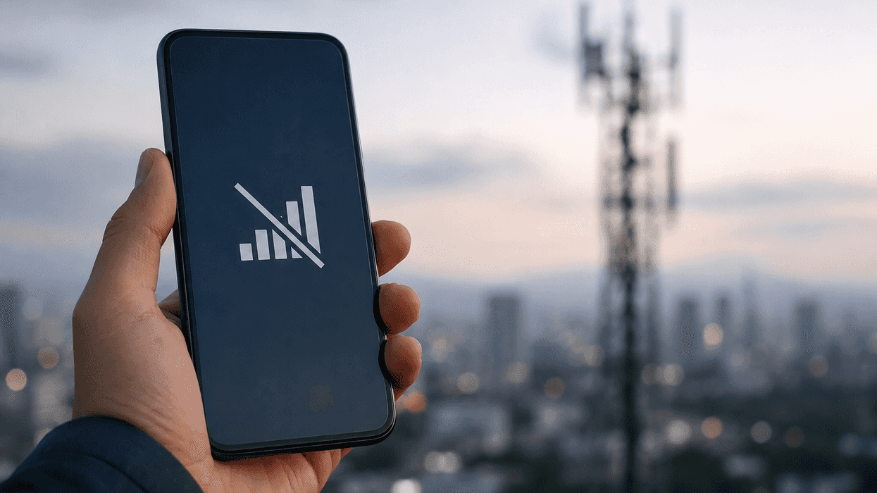 Teléfono celular sin señal frente a una antena de telecomunicaciones