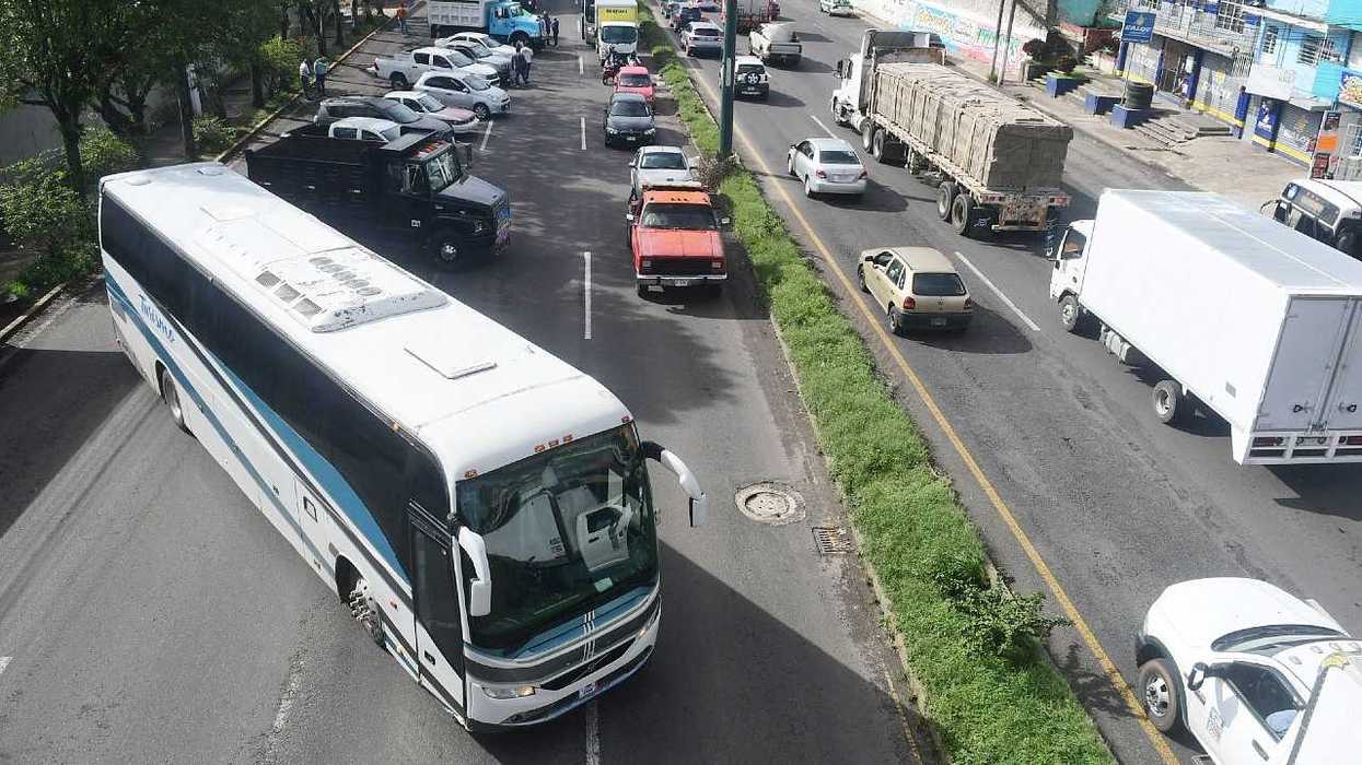 Traffic jam with a large bus and various vehicles on a busy street.