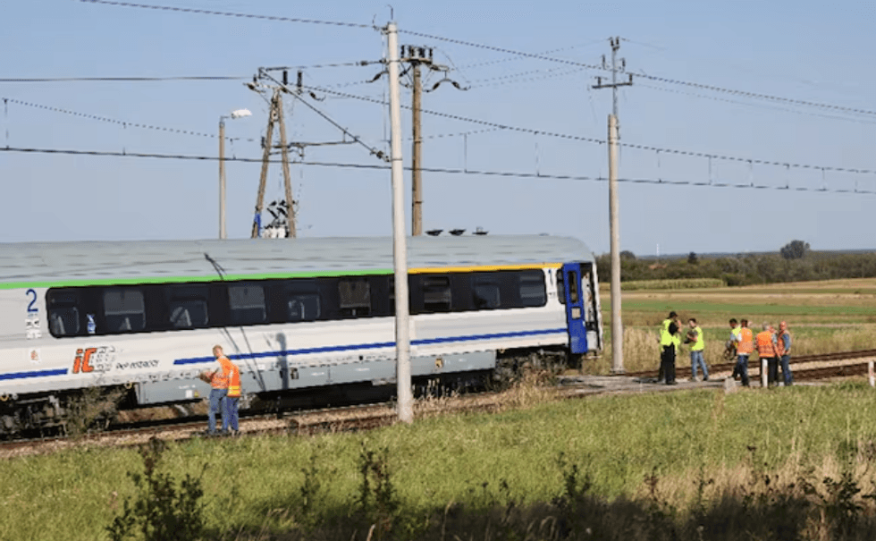 Train stopped on tracks, with workerLas causas del accidente todav\u00eda no han sido determinadass and officials gathered nearby on a sunny day.