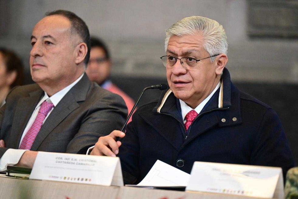 Two men in suits speaking at a conference table.